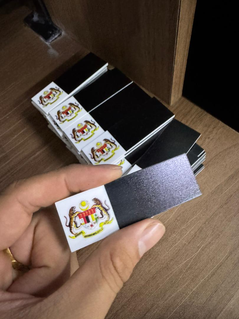 Stack of UV printed name tags with the Malaysian government crest